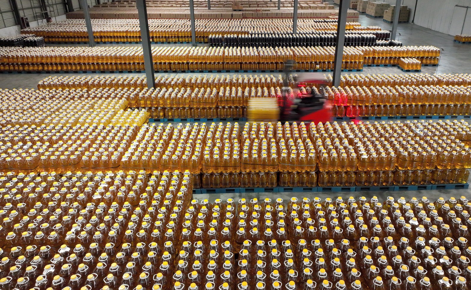 2 国家级农业产业化龙头企业金洲集团仓储区，工人正把在整齐码放的食用油搬运发货，保障市场供应。.JPG